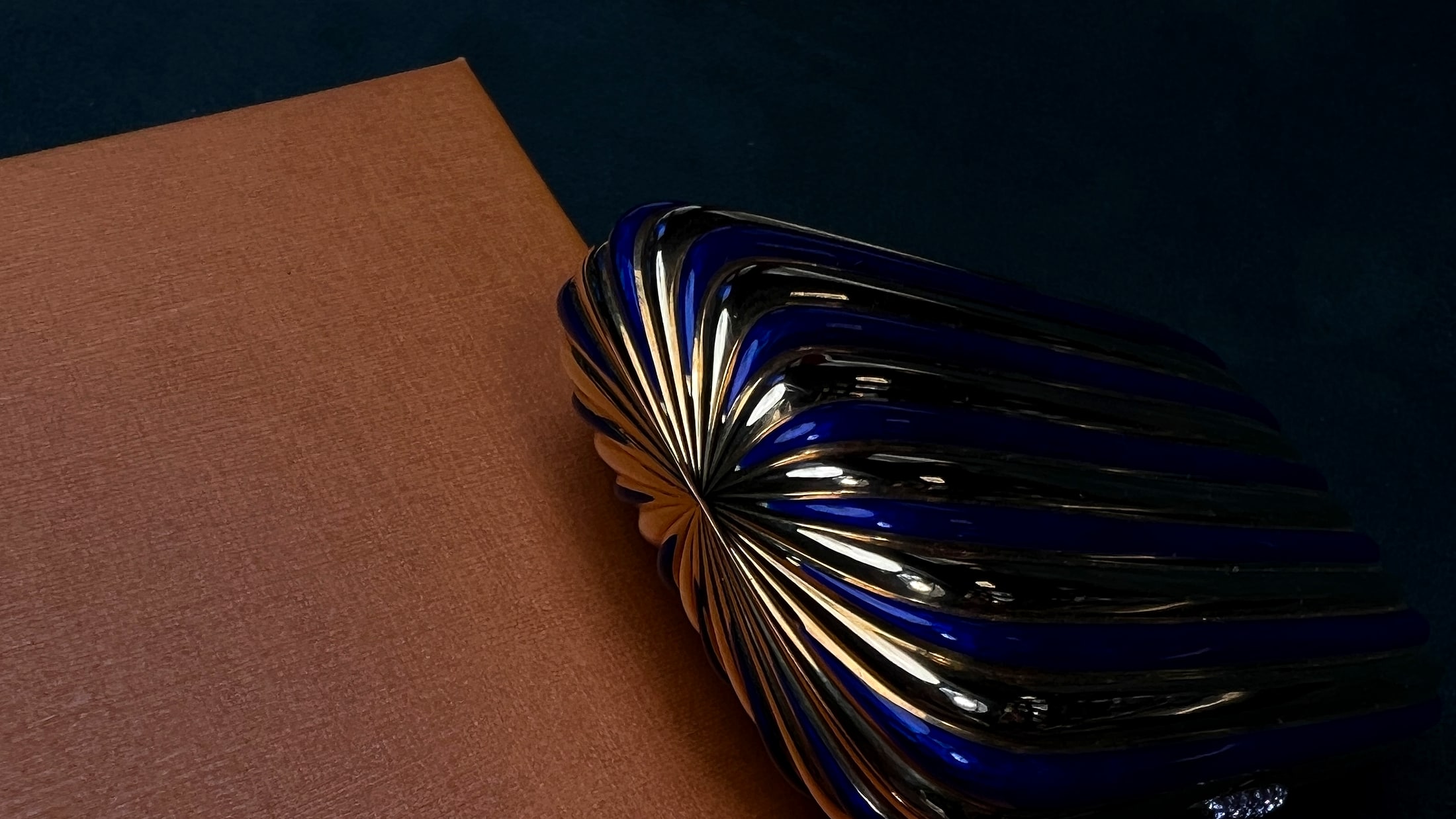 Blue enamel vintage lighter on a deep green salon surface